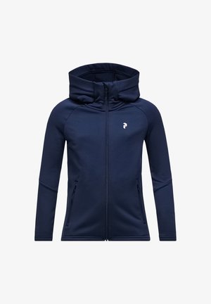 Marineblå zip-up hoodie med høj krave, sidelommer og et hvidt logo på venstre bryst lavet af blødt, fleksibelt stof.