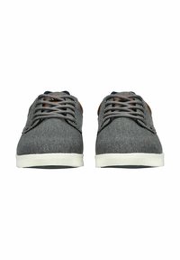 Sneakers in tela grigia con suole in gomma bianca. Le caratteristiche includono lacci piatti, una parte superiore testurizzata e dettagli in pelle marrone sul tallone.