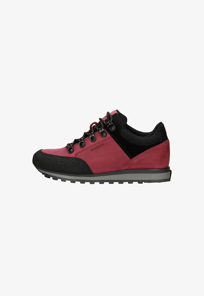 Chaussure de randonnée basse rouge et noire avec œillets métalliques, lacets noirs et semelle rainurée pour usage extérieur.