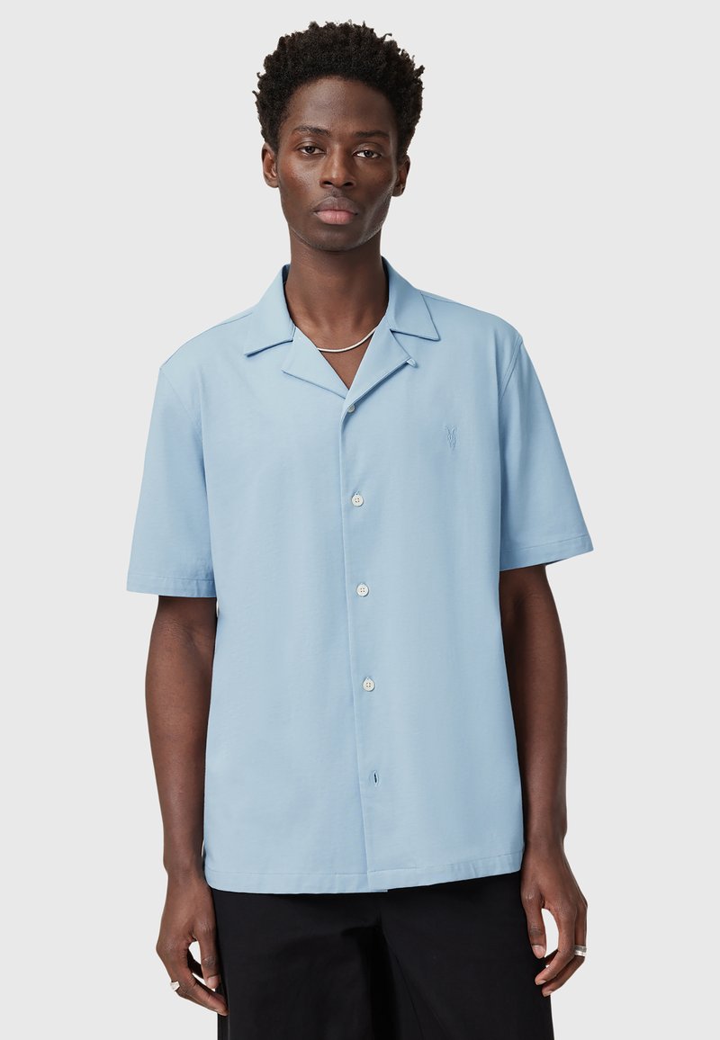 Camicia azzurra a maniche corte con colletto da campeggio, caratterizzata da un logo ricamato discreto e un tessuto leggero e morbido.