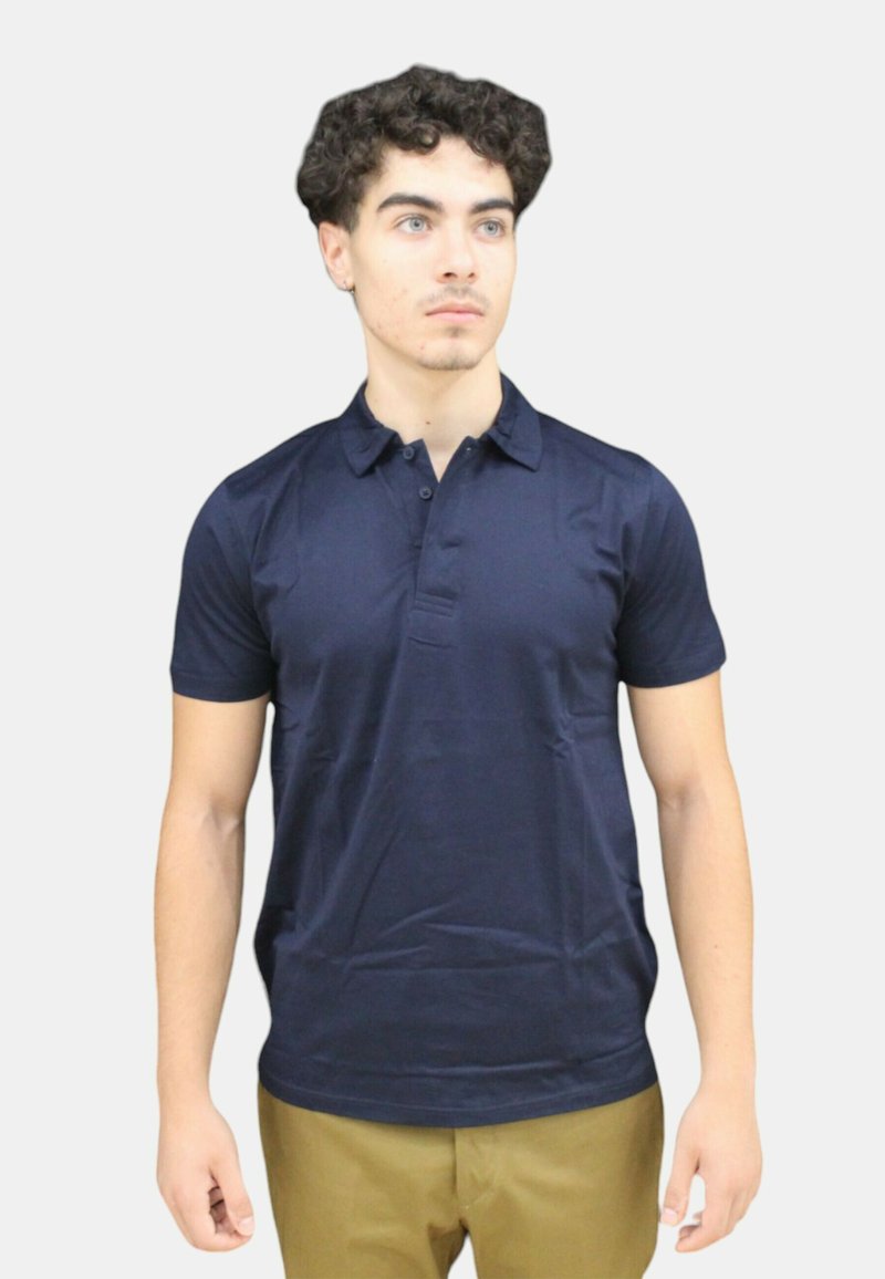 Polo navy con colletto, maniche corte e pattina con tre bottoni, realizzato in tessuto liscio, dalla forma aderente e dal design minimale.