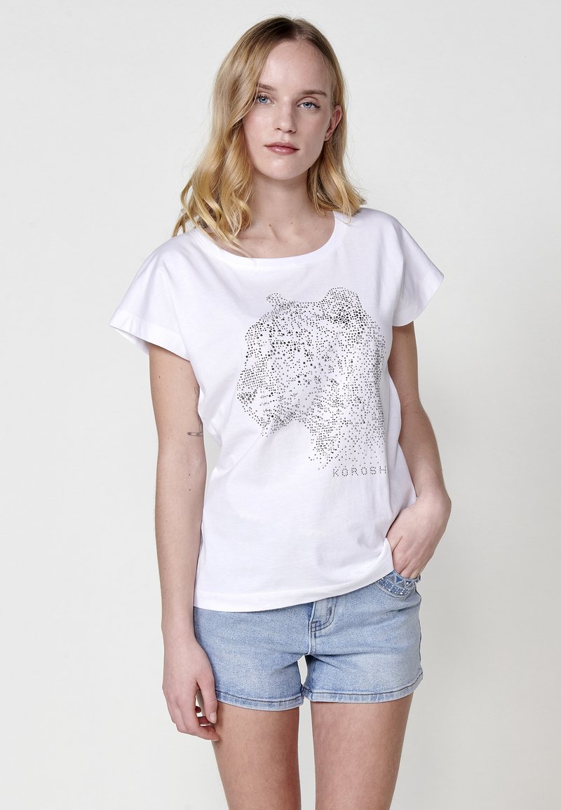 T-shirt en coton blanc à manches courtes, décoré d'un design de silhouette animale en pointillés en strass argentés. Coupe régulière, col rond.