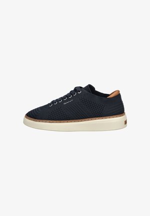 Marineblaue Mesh-Sneaker mit einer weißen Gummisohle, braunen Lederakzenten, strukturiertem Obermaterial und sechs Ösen für Schnürsenkel.