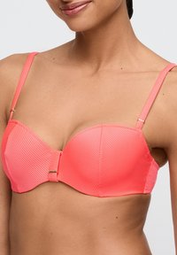 Top bikini rosa corallo con ferretto, texture a costine, spalline regolabili e chiusura in metallo dorato al centro.