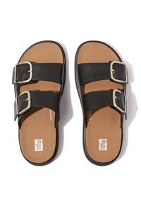 Zwarte leren sliding sandalen met twee verstelbare banden met zilveren gespen, een bruin gewatteerd voetbed en een geprofileerde zwarte zool.