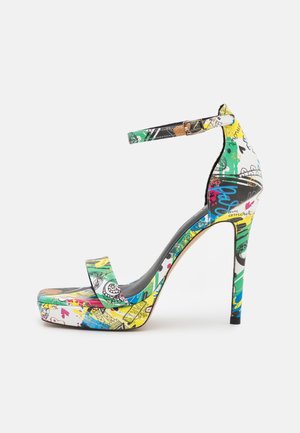 Højhælet sandal med ankelrem, platformsål og farverigt graffiti-mønster i grønne, gule, blå og sorte toner.