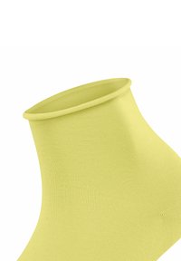 Gelbe Knöchelsocke mit geripptem Textur und einem glatten Bündchen. Der Stoff wirkt dehnbar und anschmiegsam, ideal für den täglichen Gebrauch.