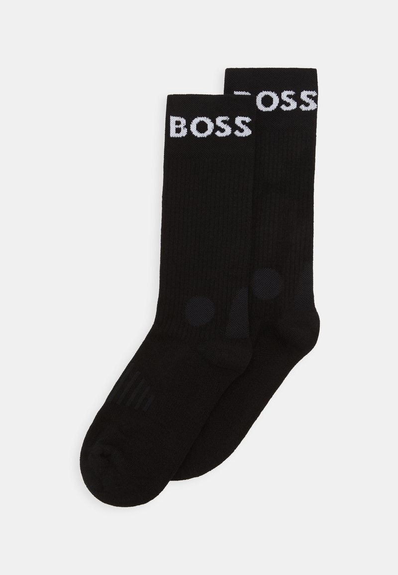 Calcetines negros con textura acanalada, que presentan un logo blanco de "BOSS" en la parte superior y discretos acentos circulares negros cerca de la base.