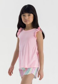 Rosa ärmlös topp med volangdetaljer vid axlarna, matchad med randiga kortbyxor i flera färger. Mjuk bomullsmaterial, lätt textur.