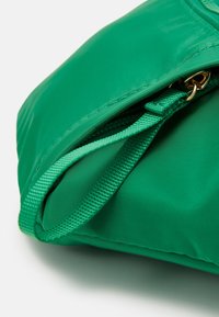 Borsa a tracolla verde in nylon con chiusura con zip, tessuto texture e manico intrecciato per una facile portabilità.