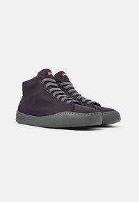 Hochschuh-Sneaker aus dunkelgrauem Canvas mit grauen Schnürsenkeln und einer strukturierten grauen Gummisohle. Besitzt ein kleines rotes Logodetail auf der Zunge.