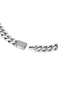 Sølv kædearmbånd med tykke led og en rektangulær lås, der prydes med små klare ædelsten. Glat metaloverflade med blank finish.