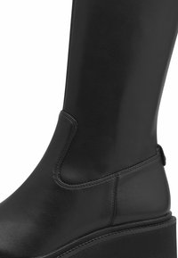 Czarne skórzane kozak z gładką fakturą, okrągłym noskiem i platformą. Posiada subtelne przeszycia oraz uchwyt z tyłu.