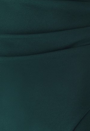 Tela verde bosque con textura lisa y mate, presenta detalles sutiles de drapeado. Exhibe un color uniforme sin patrones o acentos visibles.