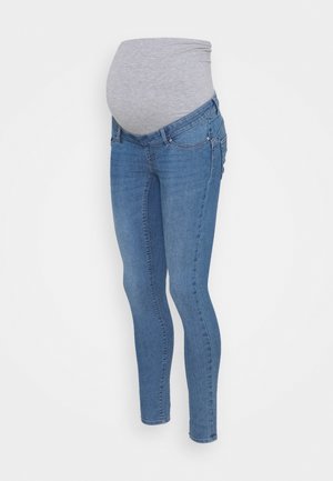 Jeans de maternité avec un panneau gris extensible sur le ventre et des jambes en denim bleu, conçus pour le confort et le soutien pendant la grossesse.