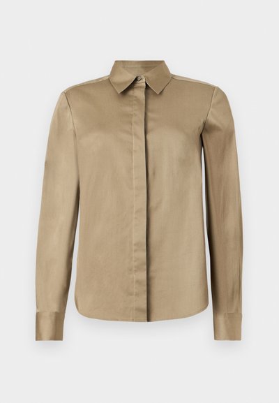 Μπεζ μακρυμάνικο πουκάμισο με κουμπιά και μυτερό γιακά, με κρυφά κουμπιά στο μπροστινό μέρος, παρουσιάζεται σε απλό ανοιχτό φόντο.