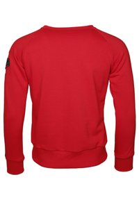 Röd sweatshirt med långa ärmar, ribbade muddar och nederkant, rund halsringning, slät yta och en liten svart logotyp på vänster axel.