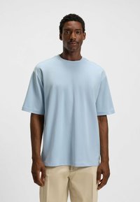 Light blue short-sleeved t-shirt in soft fabric, featuring a round neck and relaxed fit. Smooth texture; no patterns or logos visible.