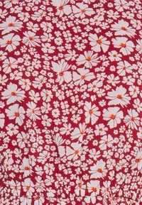 Rote Stoff mit einem weißen Blumenmuster und orangefarbenen Akzenten. Das Design umfasst große und kleine Blumen, die dicht angeordnet sind.
