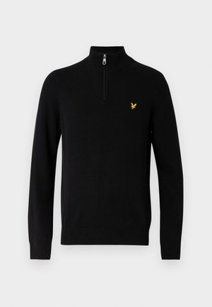 Schwarzer Pullover mit hohem Kragen und Reißverschluss bis zur Mitte. Verfügt über ein kleines gelbes Vogel-Logo auf der Brust. Glatte Textur, figurbetontes Design.