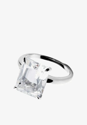 Anillo de plata con una gran piedra preciosa clara cortada en forma cuadrada, sujetada por cuatro garras, sobre una banda brillante.