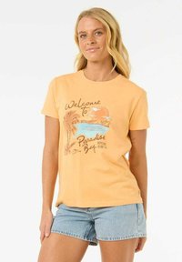 Geel katoenen T-shirt met een grafische afbeelding van een zonsondergang boven water met palmbomen en de tekst "Welkom in Paradise Bay" in bruin.