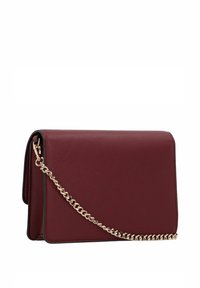 Burgundy leather crossbody bag with a textured finish, a flap closure, and a gold chain strap. Features clean lines and minimalistic design.