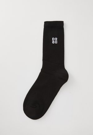 Chaussette noire à la cheville avec texture côtelée et logo "D2" blanc imprimé sur le côté. Design simple, matériau doux et forme de chaussette standard.
