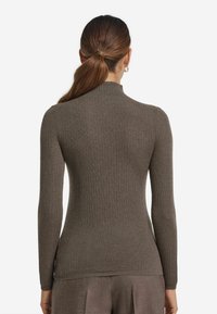 Brązowy sweter z kołnierzem typu golf z prążkowanej tkaniny, z długimi rękawami. Dopasowany krój, teksturowany materiał i subtelny połysk. Brak widocznych elementów metalowych lub wzorów.