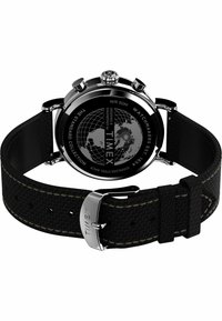 Tył zegarka Timex z czarnym, teksturowanym paskiem, stalową kopertą oraz wygrawerowanym wzorem mapy świata na tylnej części koperty.