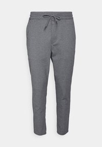 Pantalones de chándal grises con cintura elástica y cordón, piernas ajustadas y tejido suave y texturizado. No hay bolsillos visibles.