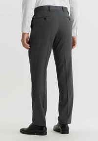 Szare spodni w kratę o dopasowanym kroju, z szlufkami na pasek i dwoma tylnymi kieszeniami, w połączeniu z czarnymi eleganckimi butami.