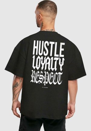 Melna pārakmeņu t-kreklu ar izteiktu balto tipogrāfiju "HUSTLE LOYALTY RESPECT" uz muguras. Īsas piedurknes un brīvāka piegriezne.