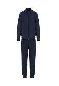 Tuta blu navy composto da una giacca con zip e colletto alto e pantaloni coordinati con polsini e vita elastici. Tessuto morbido.