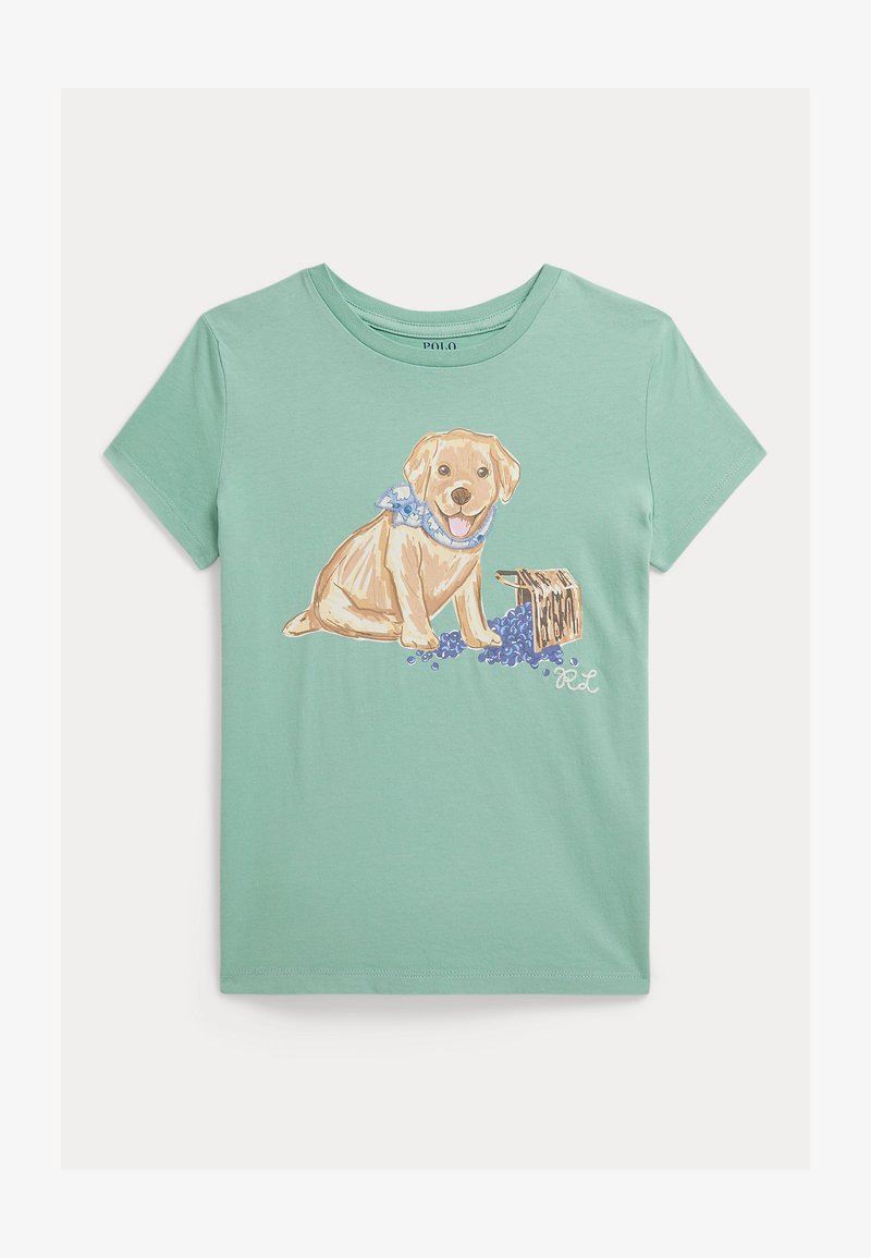 Μέντα πράσινο βαμβακερό μπλουζάκι με γραφικό ενός καθιστού κίτρινου Λαμπραντόρ με μπλε μαντήλι, δίπλα σε ξύλινο κιβώτιο και μοβ λουλούδια.