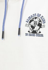 Weißer Hoodie aus Stoff mit einem Globusgrafik in Schwarz und Blau. Hellblaue Kordeln mit schwarzen Enden, versehen mit dem Text "SEI IMMER FREUNDLICH ZUEINANDER."