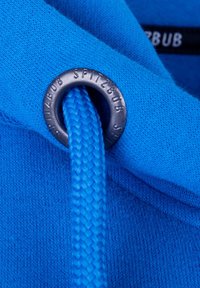 Blauwe hoodie stof met een gestructureerd oppervlak, een zilveren oogje met de gravure "SPITZBUB" en een geweven blauwe trekkoord.