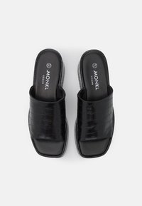 Sandales noires en cuir vegan à enfiler avec texture crocodile, bout carré et taille 37 visible sur les semelles intérieures.