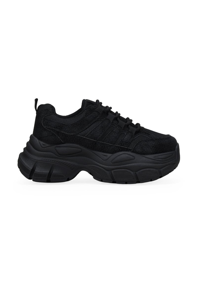 Zapatillas deportivas negras con parte superior texturizada, diseño elegante, suela acolchada y cordones elásticos. Destacan por su suela exterior de goma gruesa y estratificada.