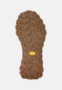 Vibram podplat iz rjave gume, ki ima agresivne zagozde za oprijem, vtisnjen logotip in oznako velikosti 42 za ustrezanje obutve.