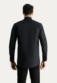 Maglietta nera a maniche lunghe con colletto strutturato e polsini con bottoni, realizzata in tessuto liscio. Vestibilità sartoriale, senza fantasie né decorazioni.