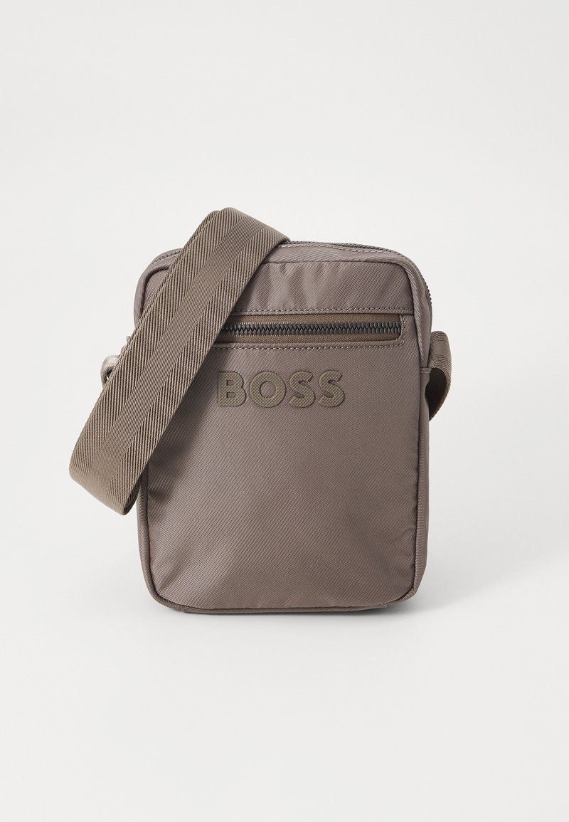 Bolso bandolera de nylon marrón con una superficie texturizada, que cuenta con un bolsillo frontal con cremallera y el logo en relieve "BOSS" en el panel frontal. Correa ajustable.