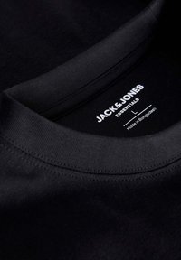 Černé bavlněné tričko s kulatým výstřihem. Má jemnou texturu a viditelné stehy. Na štítku je nápis "JACK & JONES ESSENTIALS," velikost L.