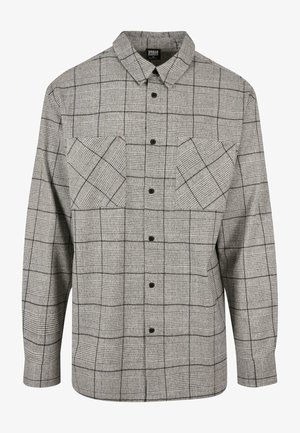 Szürke kockás flaneling, gombos elülső résszel, két zsebével a mellkasán és klasszikus gallérral. Tartalmaz egy texturált anyagmintát.