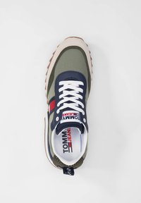 Scarpa da ginnastica verde e blu navy con lacci bianchi, striscia orizzontale rossa, suola beige testurizzata e logo sulla linguetta. Punta tonda e collo imbottito.