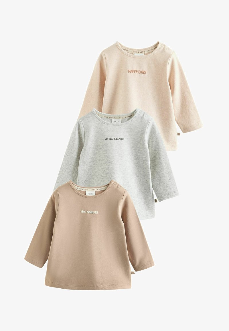 Trois hauts bébé à manches longues en beige, gris et marron clair, chacun avec un petit texte : « HAPPY DAYS », « LITTLE & LOVED » et « BIG SMILES ».