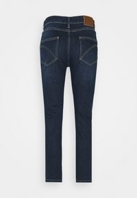 Tummansiniset farkut, joissa on kapea malli, takana ruskea nahkapatja, viisi taskua ja huomaamattomat ompeluyksityiskohdat.