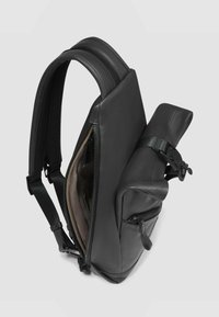 Zwarte leren rugzak met een strak ontwerp, voorzien van een hoofdritssluiting, zijvakken en verstelbare riemen. Glad oppervlak en minimalistische accenten.