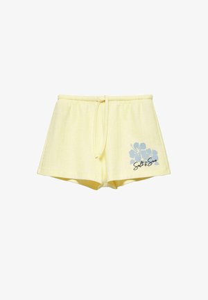 Shorts en maille jaune clair avec taille à cordon et motif fleur d’hibiscus bleu avec le texte « Salt & Sun » sur la jambe gauche.