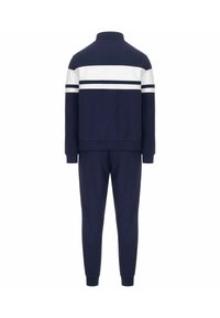 Tuta da ginnastica blu navy con strisce orizzontali bianche. Presenta un collo alto, maniche lunghe e polsini elastici sui pantaloni, realizzata in tessuto morbido.